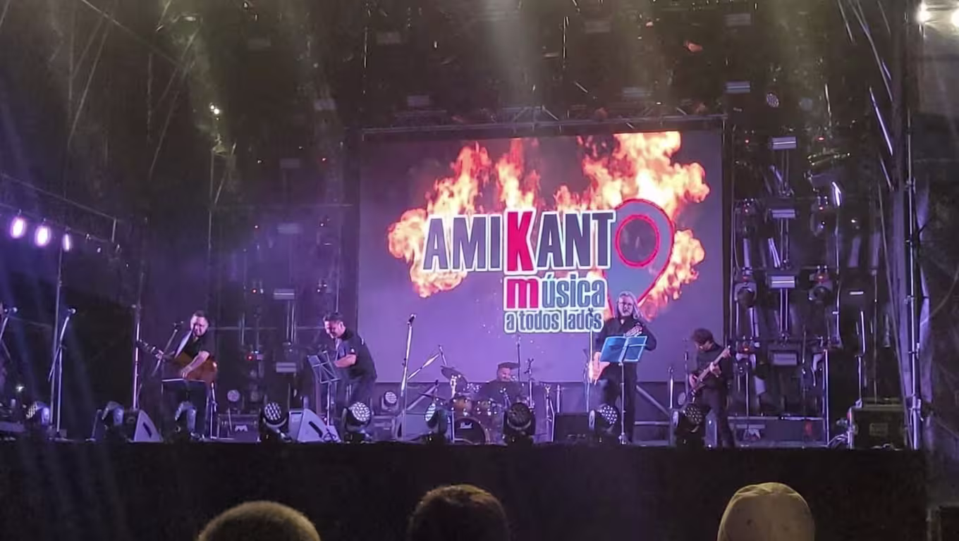 Cantantes de Amikanto mirando al público en el escenario con luces azules.