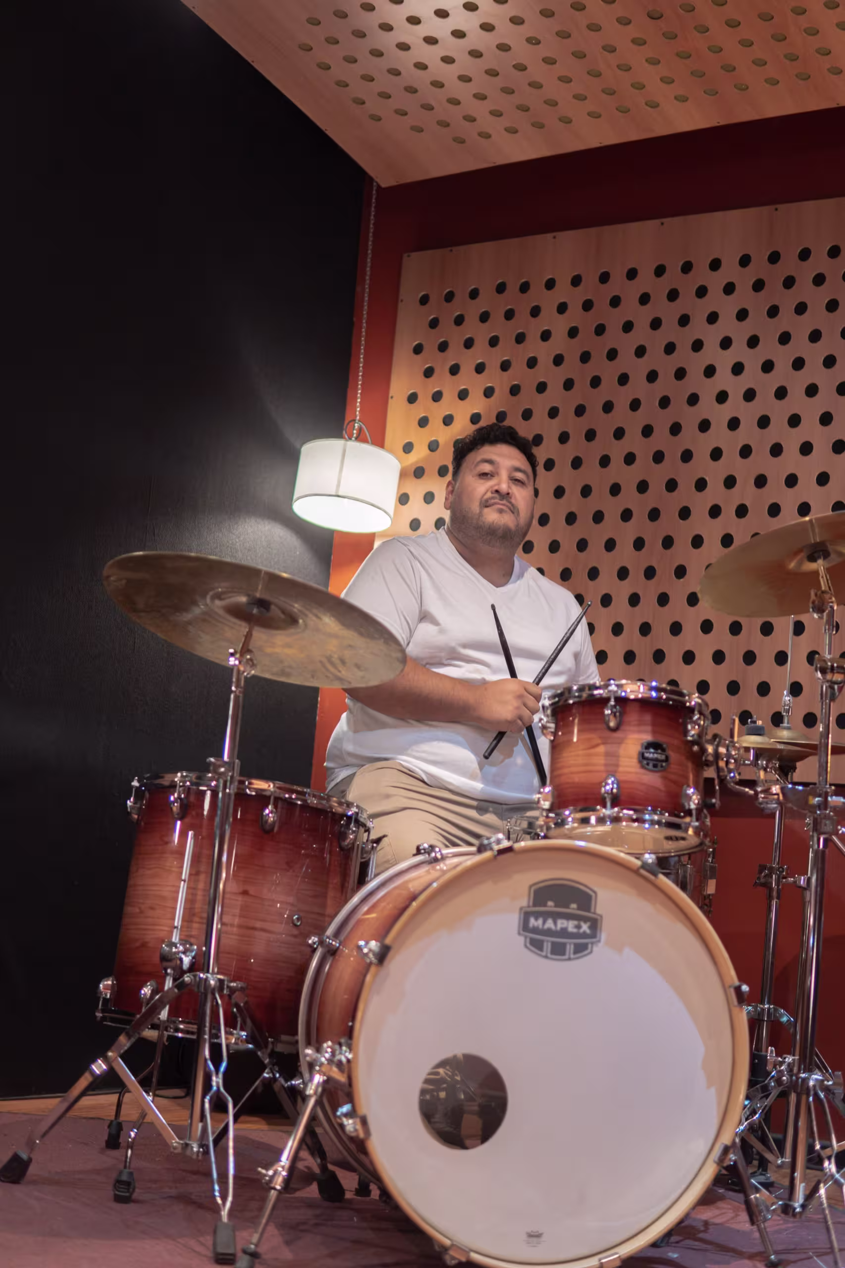 Renzo Galiñanes posando en estudio de grabación Tuyo Diapasón, apoyado en una bateria.